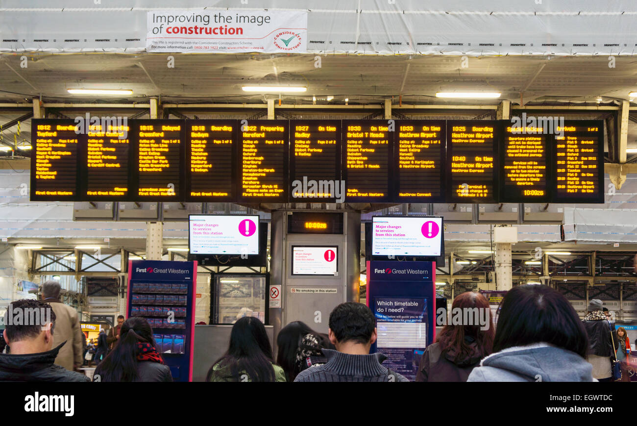 Costruzione alla stazione Paddington di Londra con persone che guardano le schede di partenza Foto Stock
