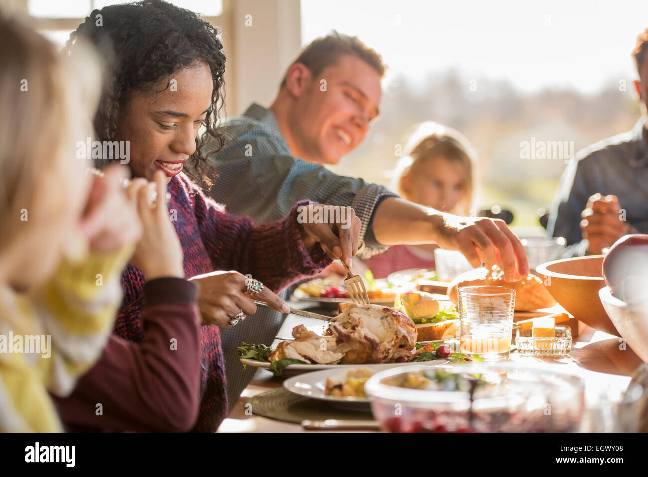 Un gruppo di persone, adulti e bambini seduti attorno a un tavolo per un pasto. Foto Stock