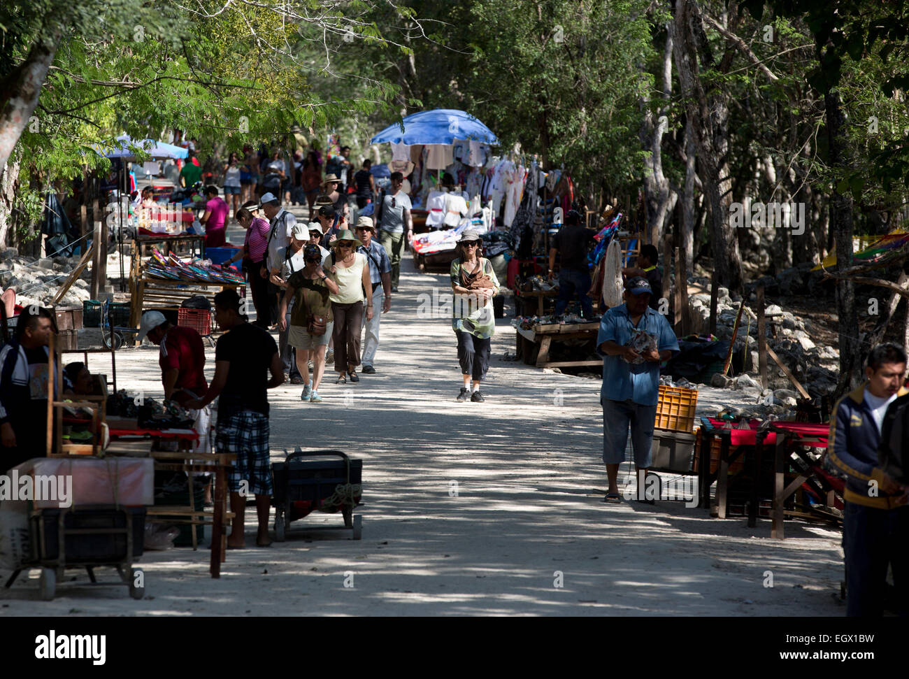 I turisti a piedi lungo un percorso foderato con fornitori di souvenir presso le rovine Maya di Chichen Itza, Yucatan, Messico Foto Stock