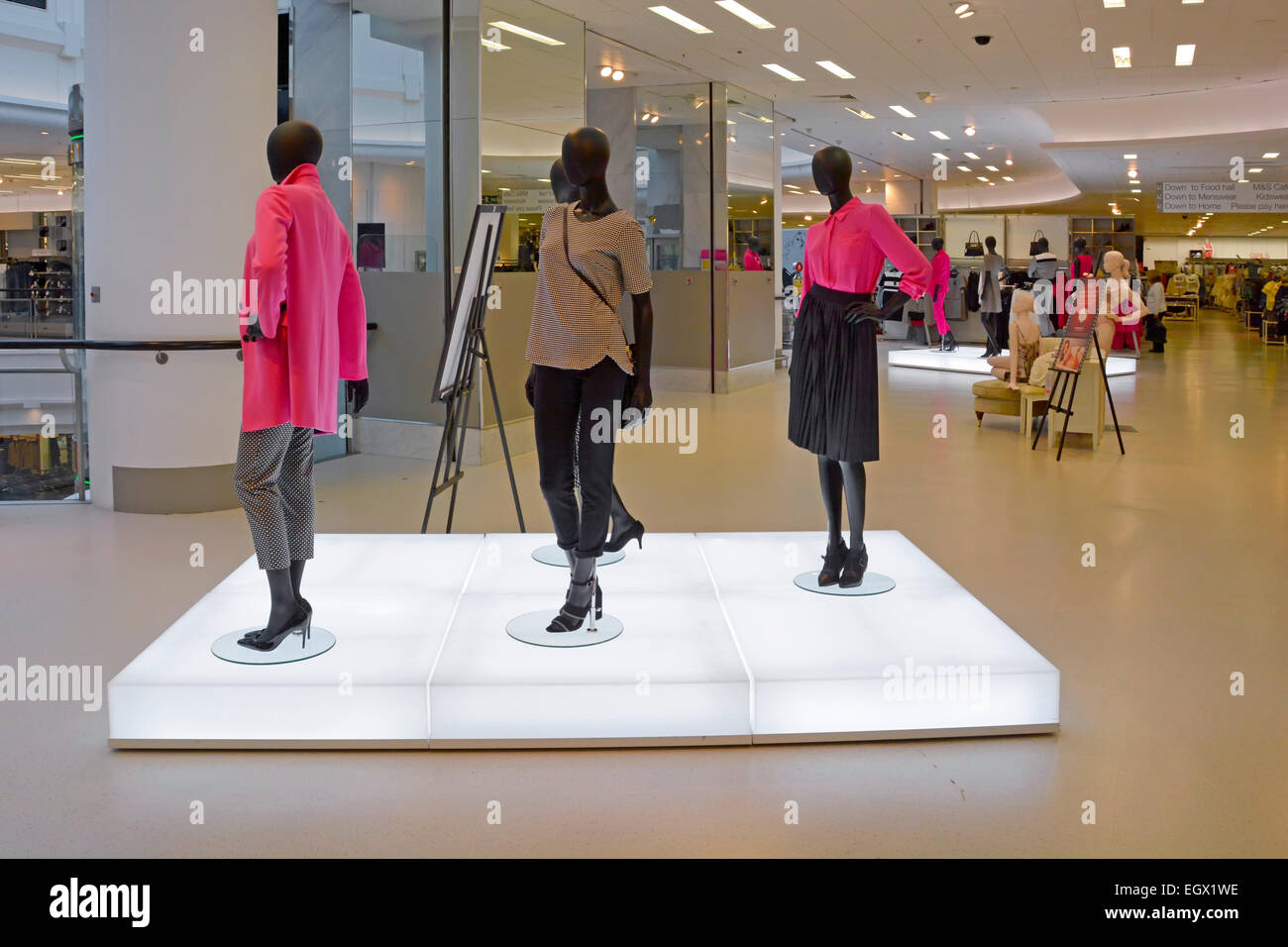 Interno della Marks & Spencer negozio con piedistallo illuminato la visualizzazione di moda per signore su manichini Essex England Regno Unito Foto Stock