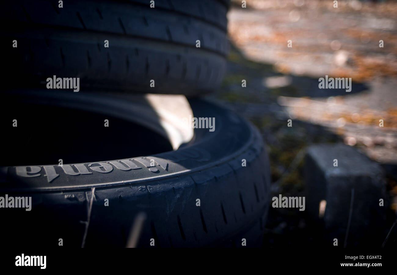 Close up di luce che cade sul mucchio di dumping illegale di pneumatici per auto, UK campagna Foto Stock