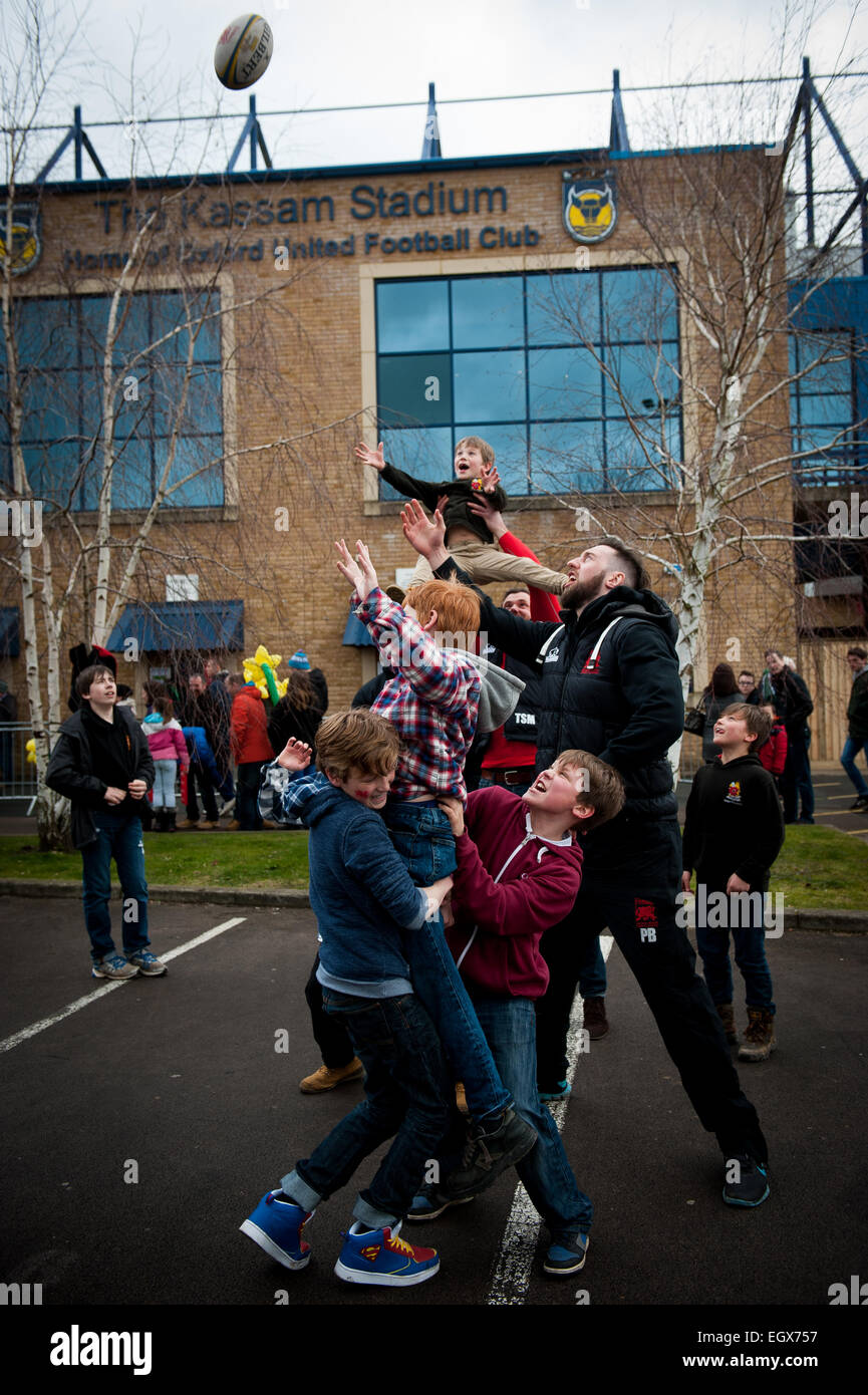 Bambini locali fare una linea di rugby con giocatori da London Welsh Rugby ai Kssam Stadium Foto Stock