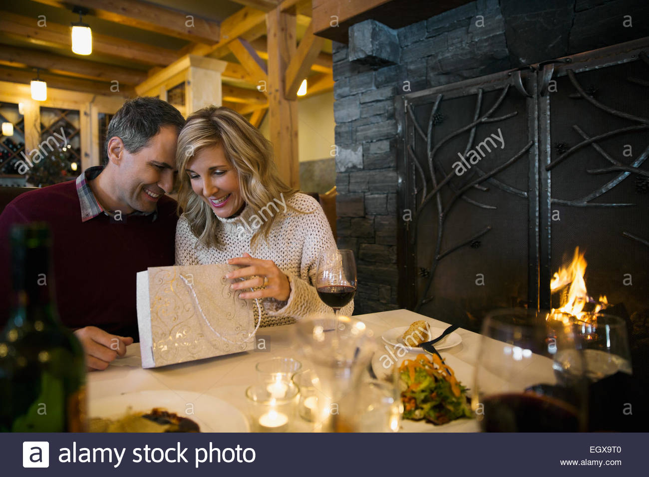 Uomo Donna dando il regalo al ristorante con caminetto tabella Foto Stock