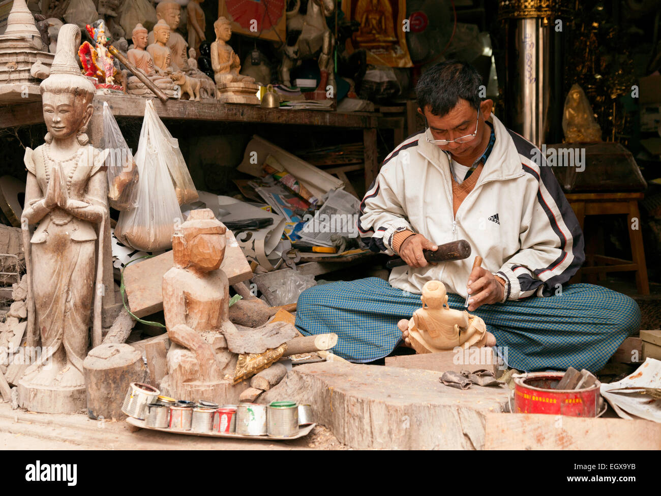 Un artigiano birmano nel suo negozio facendo una statua in legno del Buddha in vendita, Mandalay Myanmar ( Birmania ), Asia Foto Stock