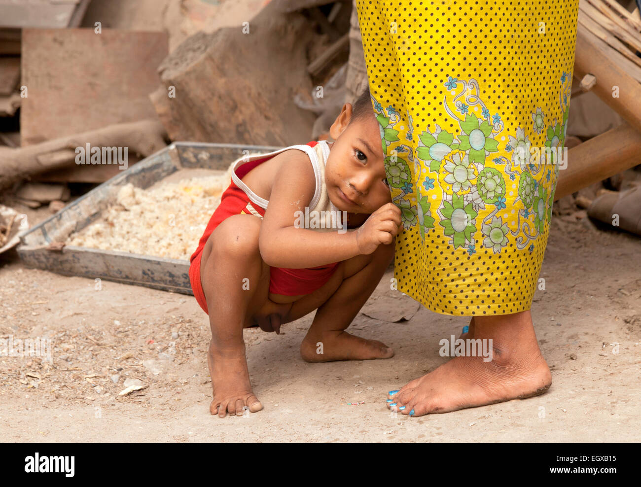 Timido bambino ragazzo birmano nascondendo nel suo mantello delle madri, Mandalay Myanmar ( Birmania ), Asia Foto Stock