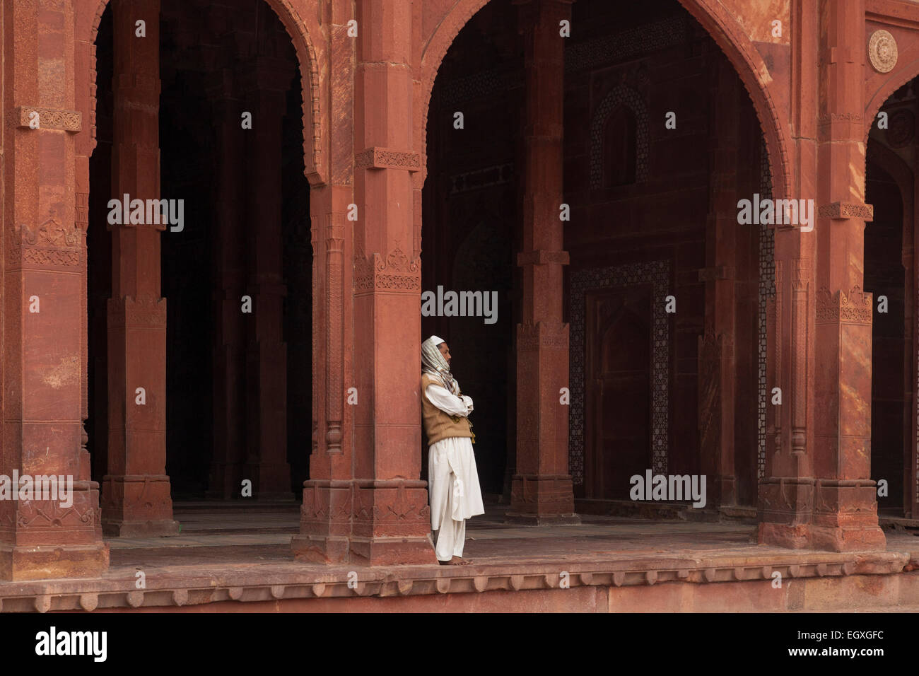 Uomo musulmano in piedi da una colonna di Fatehpur Sikri, Uttar Pradesh, India Foto Stock
