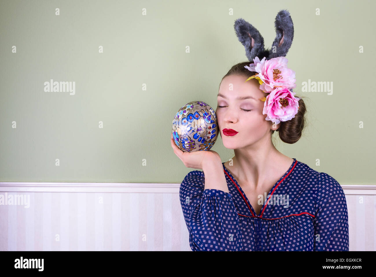 Signora giovane con orecchie di coniglietto tenendo un grande uovo di pasqua Foto Stock