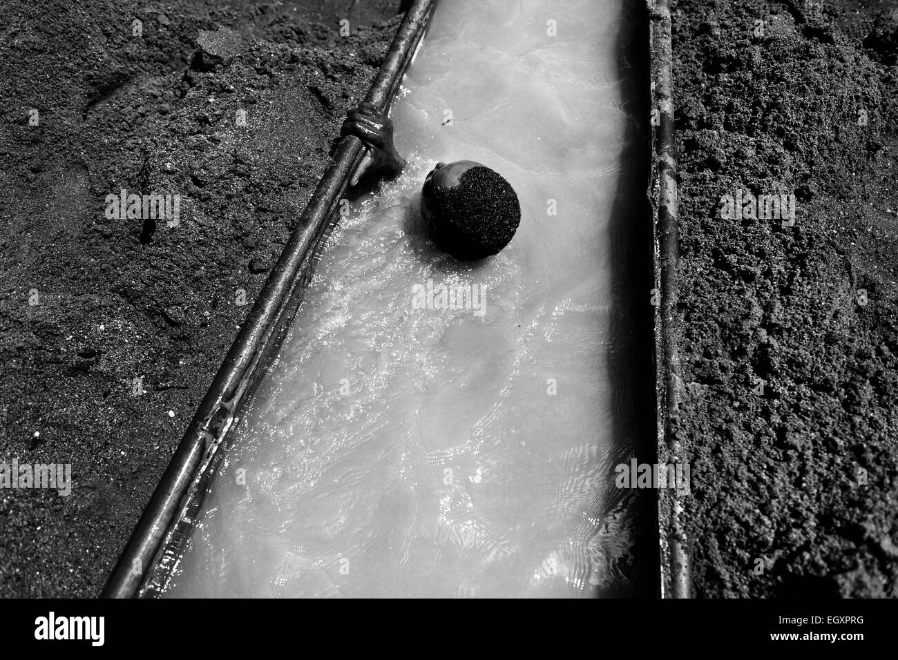 Un colombiano sabbia miner si tuffa sotto l'acqua per estrarre la sabbia dal fondo del fiume in Cartago, Colombia. Foto Stock