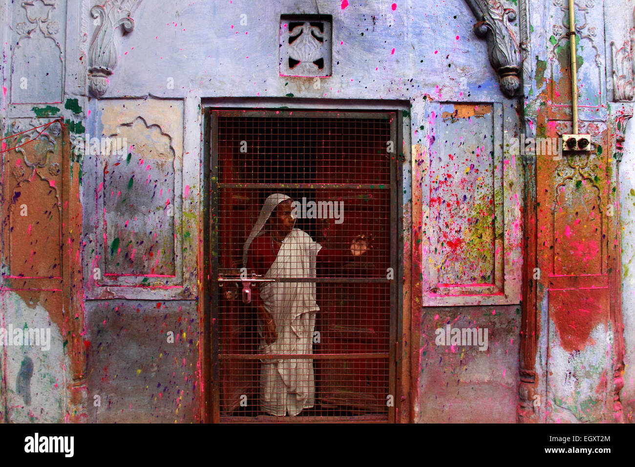 Ashram, Vrindavan, India. 03 Mar, 2015. Una vedova si erge a loro la porta della stanza a guardare il Holi celebrazione martedì al secolo vecchio 'Pagal Baba Ashram' in Vrindavan, India. È probabilmente la prima volta quando le vedove da Varanasi uniscono le loro sorelle in Vrindavan per celebrare la festa di colori, la rottura di una secolare tradizione indù, una release emesse dalle ONG Sulabh International ha detto. © Shashi Sharma/Pacific Press/Alamy Live News Credito: PACIFIC PRESS/Alamy Live News Foto Stock