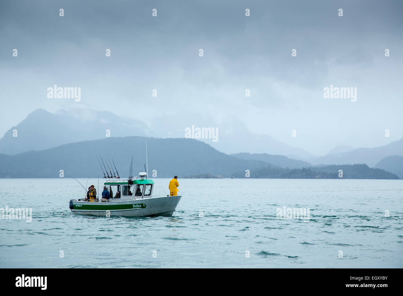 La pesca in barca a vela in un mare calmo durante un giorno nuvoloso Foto Stock