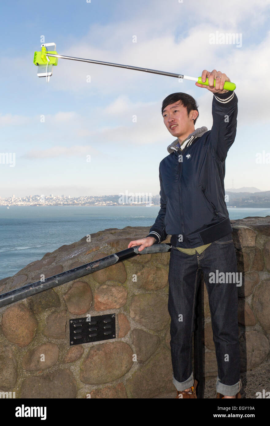 Uomo asiatico, selfie stick, tenendo selfie, selfie foto, punto di vista, lato nord del Golden Gate Bridge, città di Sausalito, Sausalito, California Foto Stock