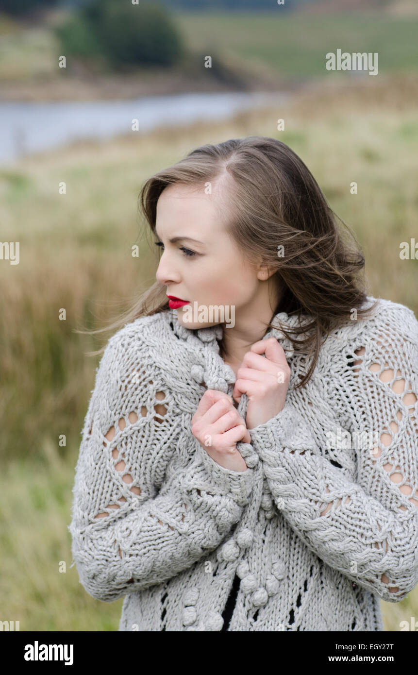 Bella giovane donna in piedi nella campagna che guarda lontano Foto Stock