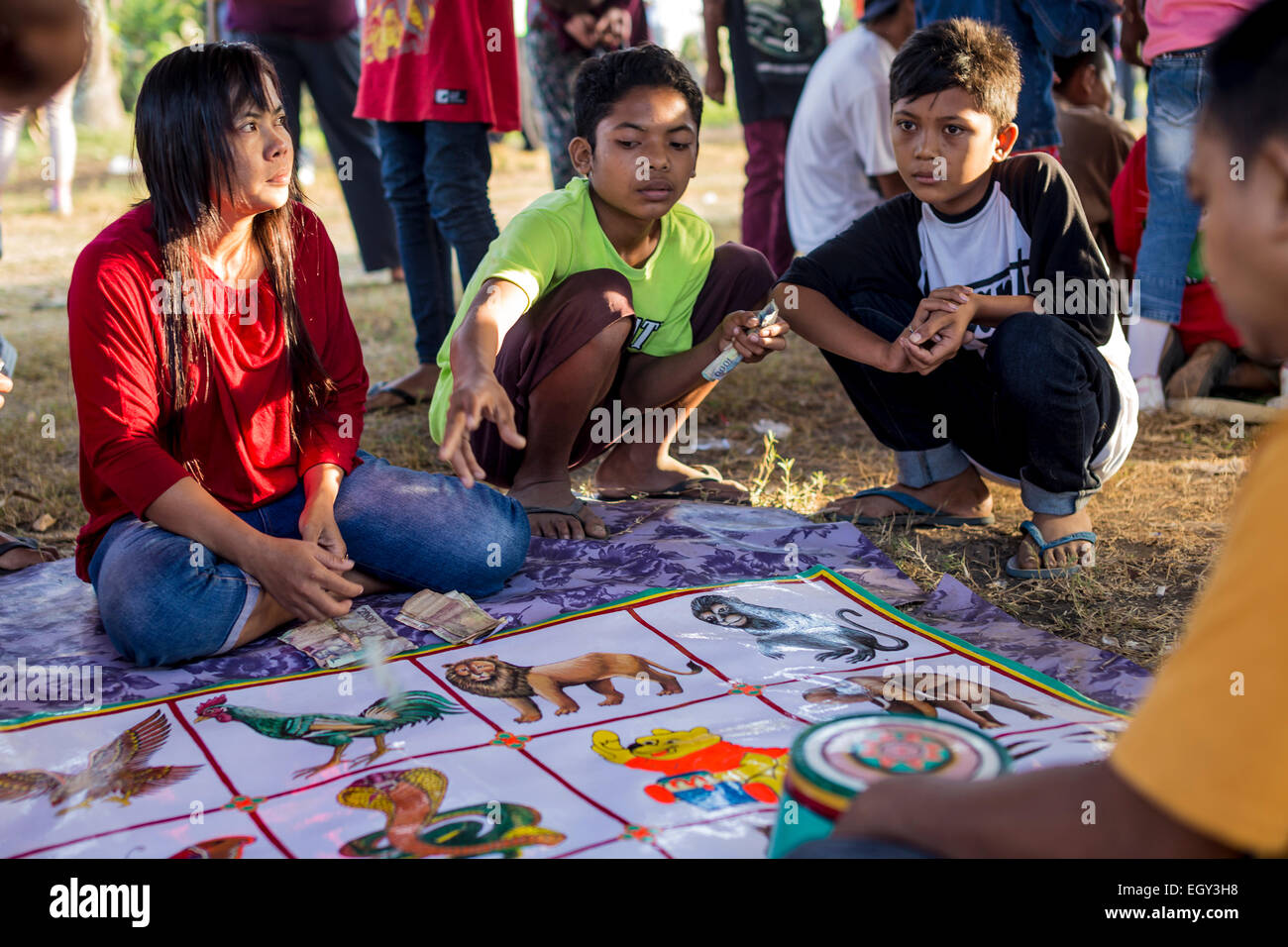 Si tratta di succede durante una grande festa del villaggio. Adulti e bambini giocare con il tasso di cassa. Questo nonostante il fatto che l'Indonesia è un paese musulmano e il gioco d'azzardo è proibito qui. Foto Stock