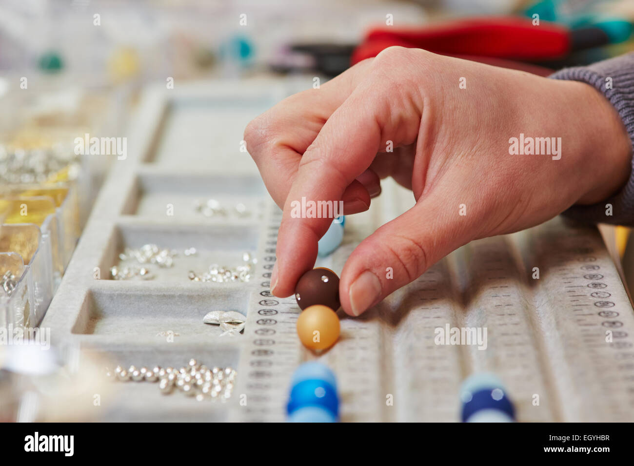 La mano di un designer di gioielli in un workshop il prelievo una perla Foto Stock