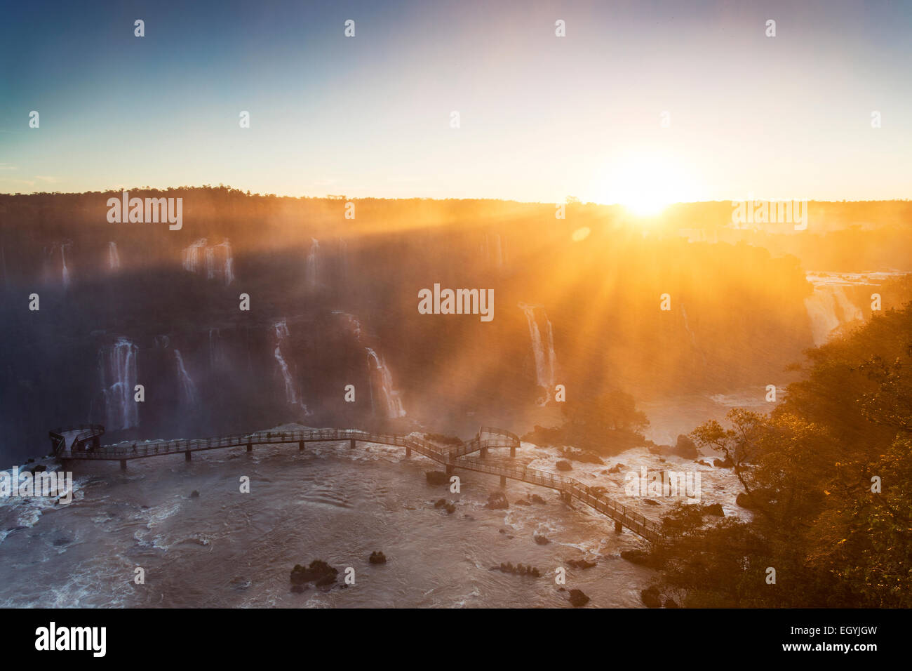 Sud America, Brasile, Parana, Parco Nazionale di Iguazu, Iguazu Falls contro il sole di sera, piattaforma di visualizzazione Foto Stock