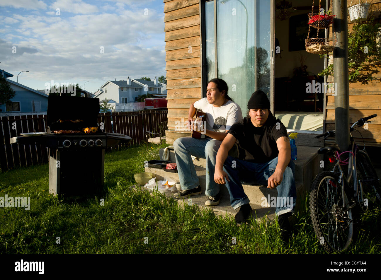 Due giovani uomini sedersi sul retro passo in Fort McMurray. Foto Stock