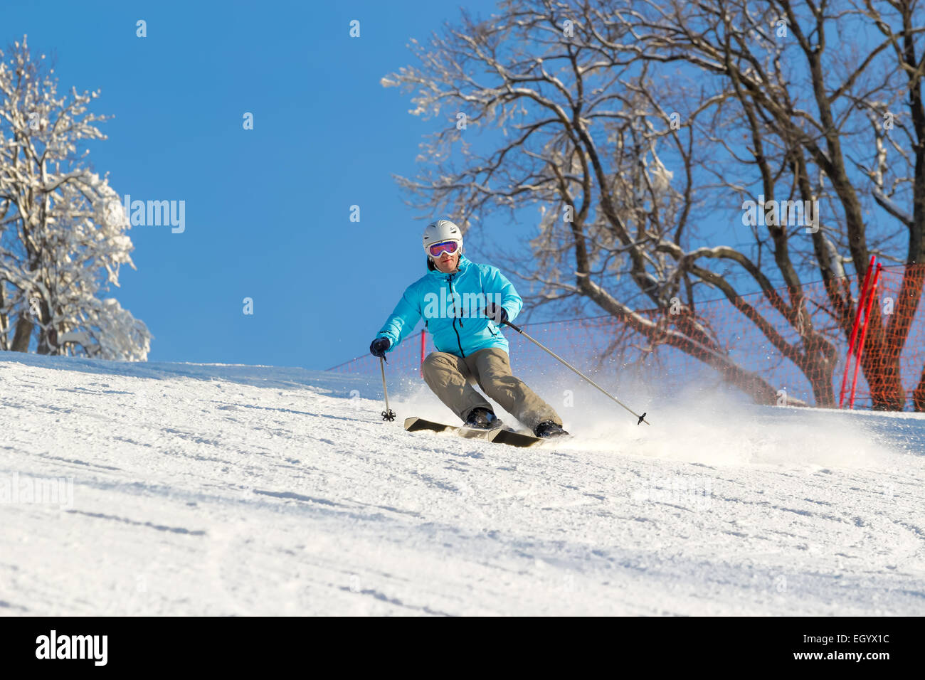 Sciatore ad alta velocità su pista nella neve soffice in una giornata di sole. Profondità di campo Foto Stock