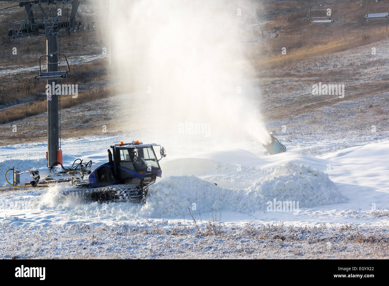 Neve cannoni produce e il gatto delle nevi leviga, neve artificiale sulle piste dello ski resort Foto Stock