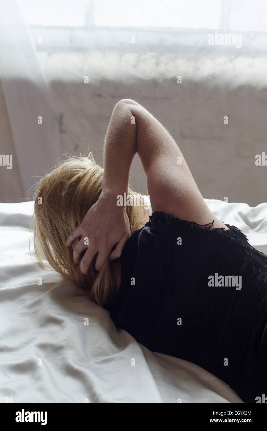 Giovane donna a letto Foto Stock