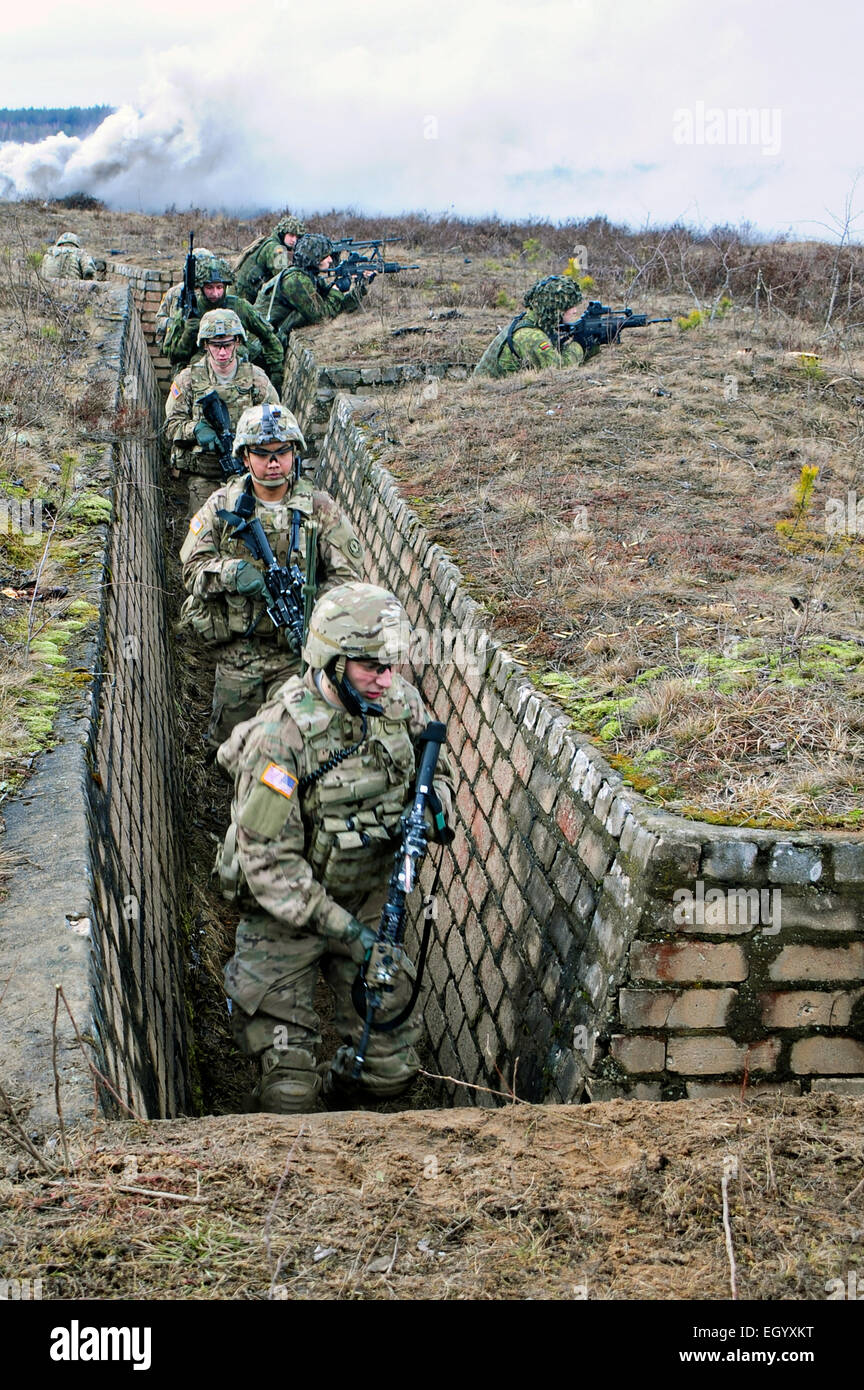 Noi soldati dell esercito per uscire da una trincea sotto il fuoco di copertura dalla Lithuanian Granduca Algirdas meccanizzata del battaglione di fanteria durante un'esercitazione a fuoco parte di Operazione Atlantic risolvere Marzo 3, 2015 in Pabrade, Lituania. Foto Stock