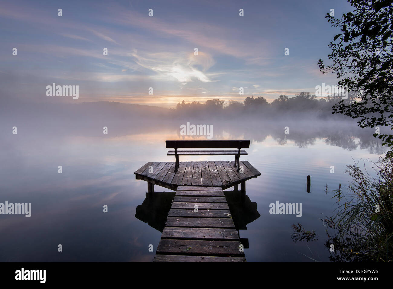 In Germania, in Baviera, Wessling, Wesslinger vedere, boardwalk con panca in legno di mattina nebbia Foto Stock