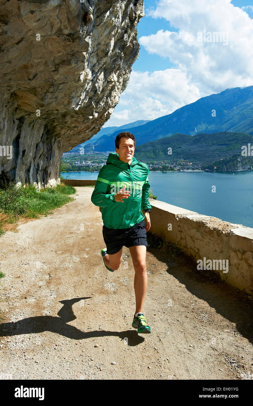 L'Italia, Trentino, uomo che corre in riva al lago di Garda Foto Stock