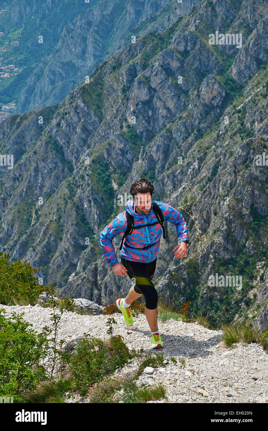 L'Italia, Trentino, uomo corsa in montagna vicino al Lago di Garda Foto Stock