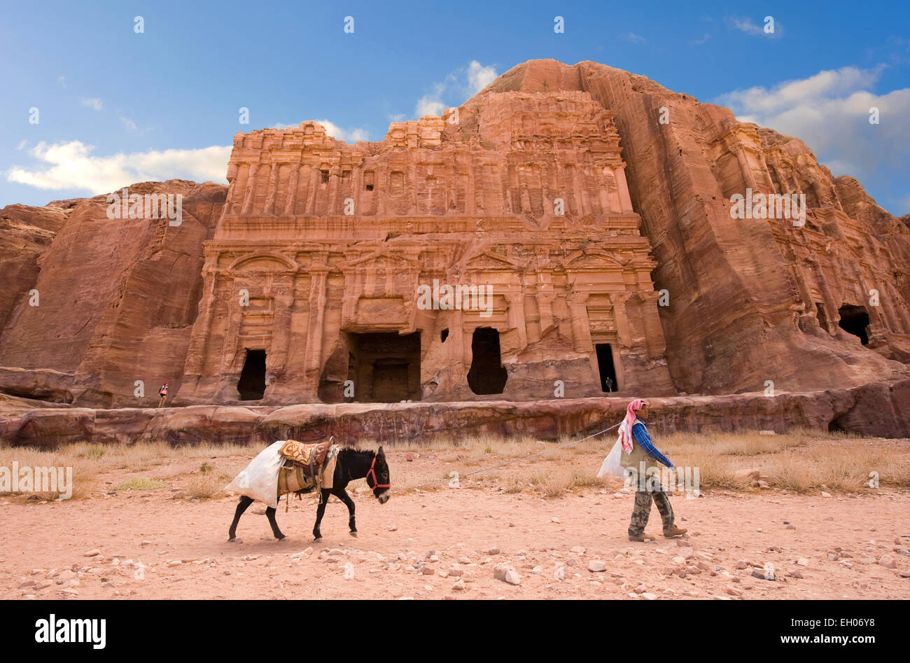 PETRA, GIORDANIA - Ott 12, 2014: l'uomo con un asino è passando davanti al palazzo tomba in Petra in Giordania Foto Stock