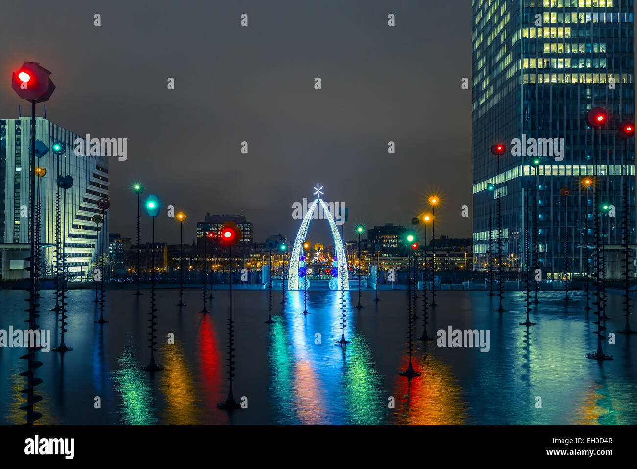 Fontana multicolore e illuminato Arc de Triomphe, vista dall'Esplanade de La Defense in notturna a Parigi, Francia Foto Stock
