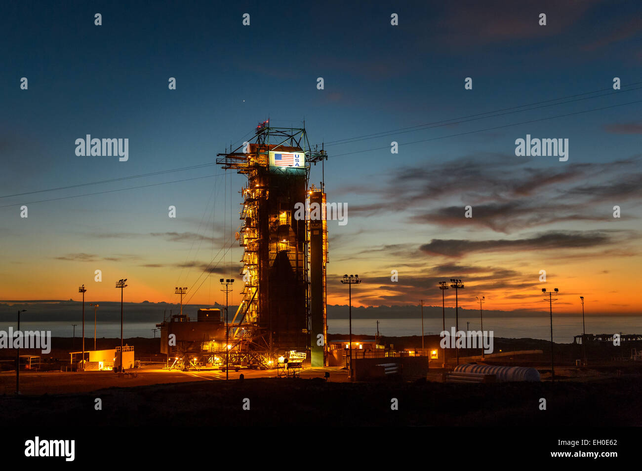 Il sole tramonta dietro il lancio nello spazio di 2 complessi (SLC-2) con il razzo Delta II e l'umidità di suolo attivo Passivo (SMAP) osservatorio protetto dalla struttura di servizio il Martedì, Gennaio 27, 2015, a Vandenberg Air Force Base in California SMAP è di NASA prima terra-satellite di osservazione progettato per raccogliere le osservazioni globali di superficie l'umidità del suolo e il suo congelamento/scongelamento di stato. SMAP fornirà alta risoluzione globale le misurazioni di umidità del suolo da spazio. I dati saranno utilizzati per migliorare gli scienziati la comprensione dei processi che il collegamento della massa di acqua e di energia e cicli di carbonio. Foto Stock