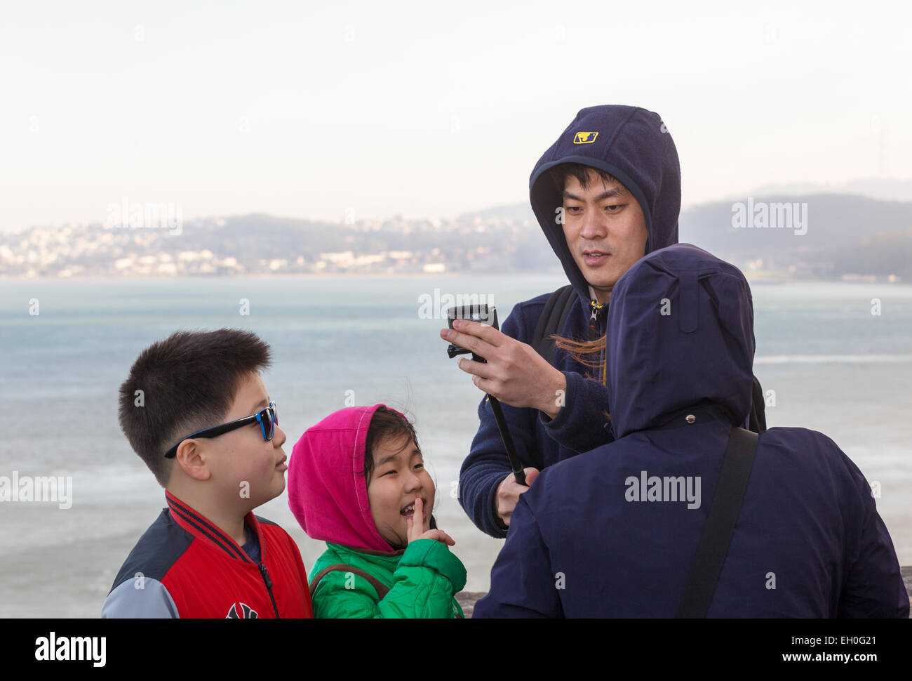 Uomo asiatico, utilizzando selfie stick, tenendo selfie foto, punto di vista, lato nord del Golden Gate Bridge, città di Sausalito, sausalito, California Foto Stock