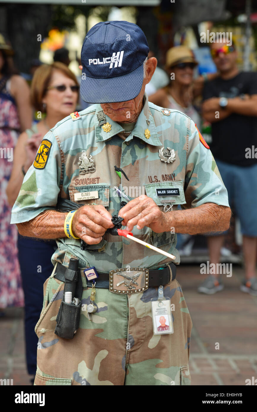Il vecchio uomo vestito in abiti militari impegnati con le sue mani e guardando verso il basso. Ponce, Puerto Rico. Febbraio 2015. Foto Stock