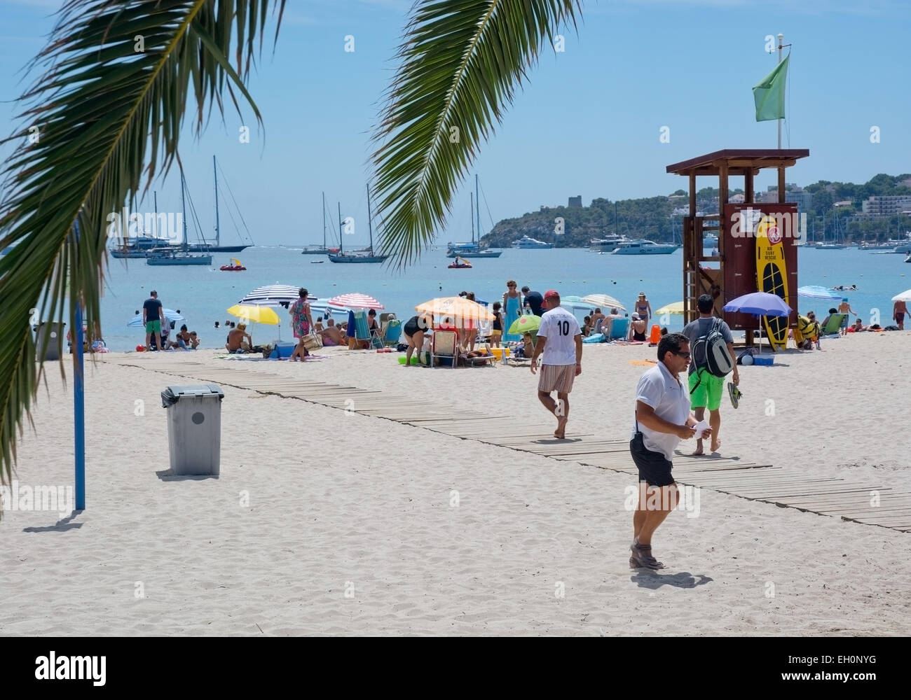 PALMA NOVA, Maiorca, isole Baleari, Spagna - Luglio 20, 2014: Spiaggia scena con turisti e lucertole da mare, barche ormeggiate in mare Foto Stock