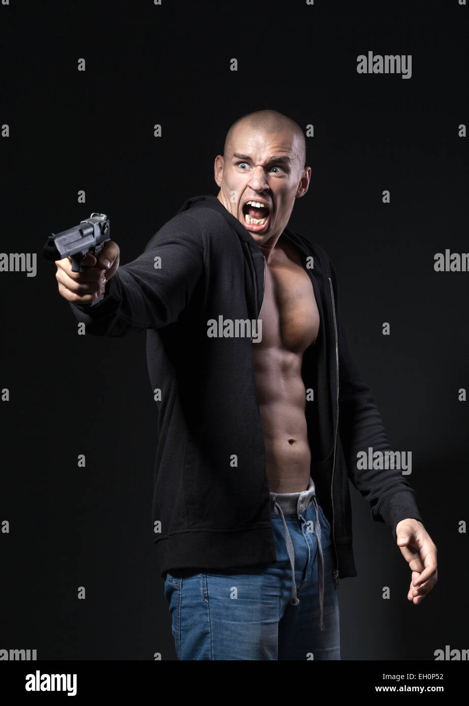 Spaventata uomo pistola tiro isolato su sfondo nero Foto Stock