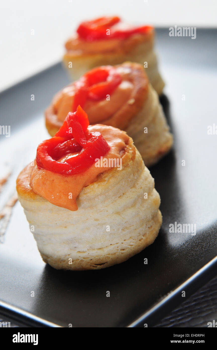 Una piastra con alcuni volauvents riempito con pepe rosso e salsa al formaggio, servita come antipasto Foto Stock