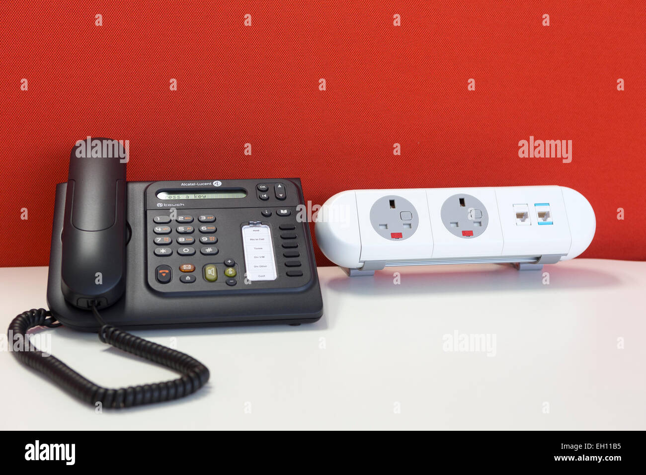 Sistema telefonico e prese di alimentazione in un ufficio moderno interno con un piano aperto desking Foto Stock