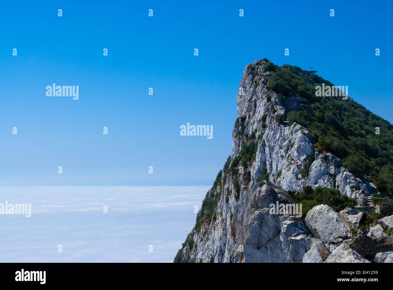 Rocca di Gibilterra il picco sopra le nuvole contro il cielo blu e chiaro. Foto Stock
