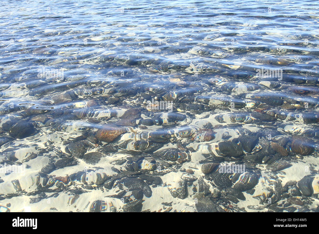 Acqua cristallina vicino alla spiaggia con rocce sottomarine visibile Foto Stock