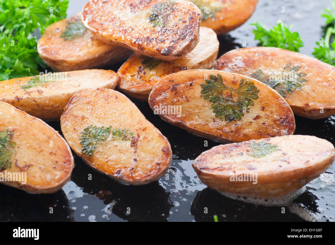 In casa foglie di prezzemolo patate cotto al forno con burro fuso e il sale. Foto Stock