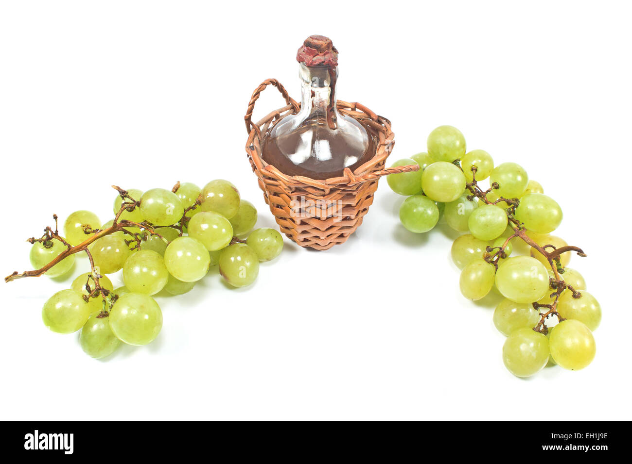 Vecchio sigillato bottiglia di vino e uva bianca isolata su bianco Foto Stock