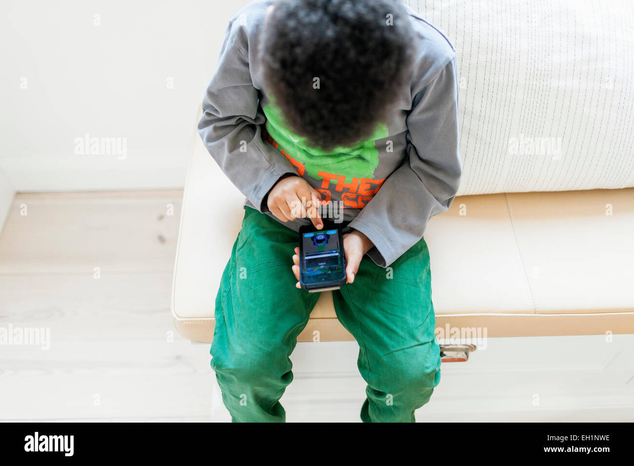 Angolo di Alta Vista del ragazzo giochi su smart phone a casa Foto Stock