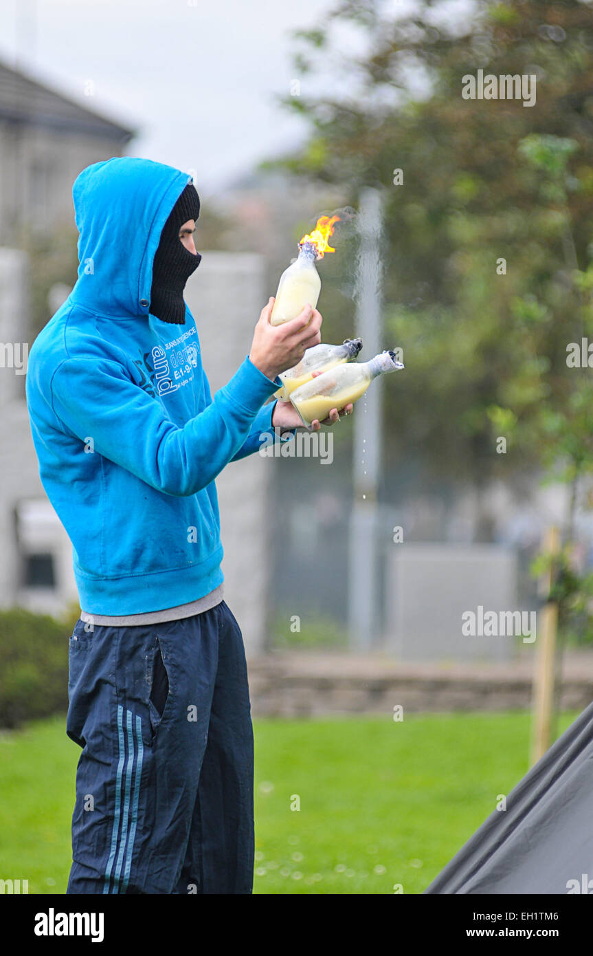 Gioventù nazionalista preparando a lanciare una bomba di benzina durante disordini nel Bogside, Derry, Londonderry, Irlanda del Nord Foto Stock
