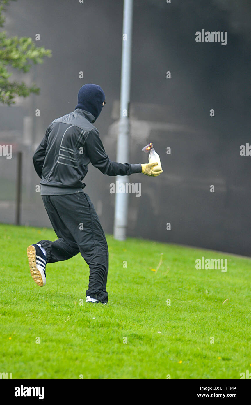 Gioventù nazionalista preparando a lanciare una bomba di benzina durante disordini nel Bogside, Derry, Londonderry, Irlanda del Nord Foto Stock