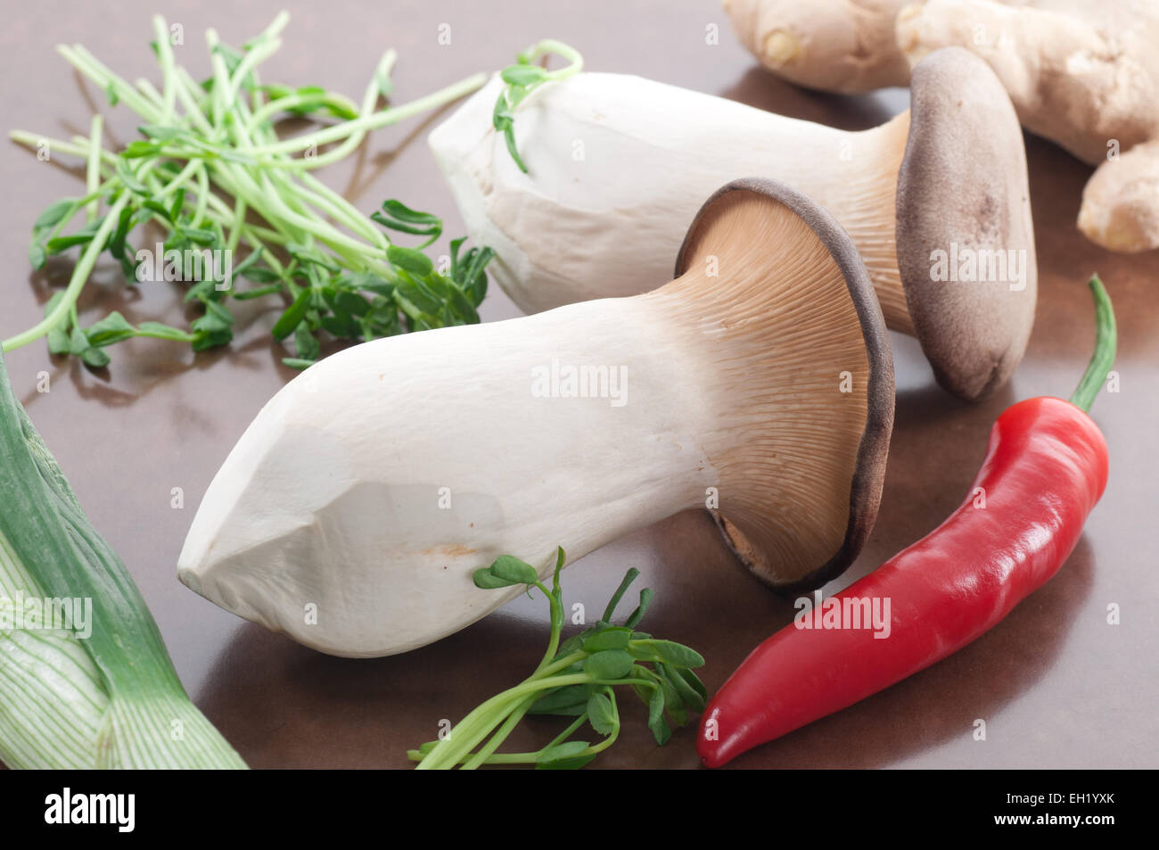 Re funghi Oyster, peperoncino rosso, germogli di piselli, porri e zenzero fresco. Foto Stock