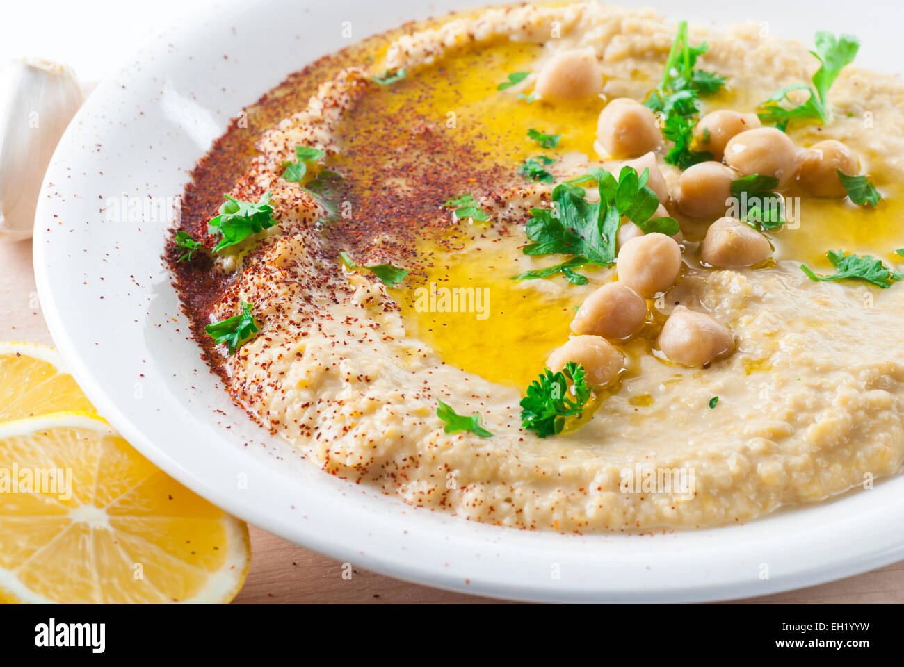 Hummus condito con olio d'oliva, peperoncino e prezzemolo. Foto Stock