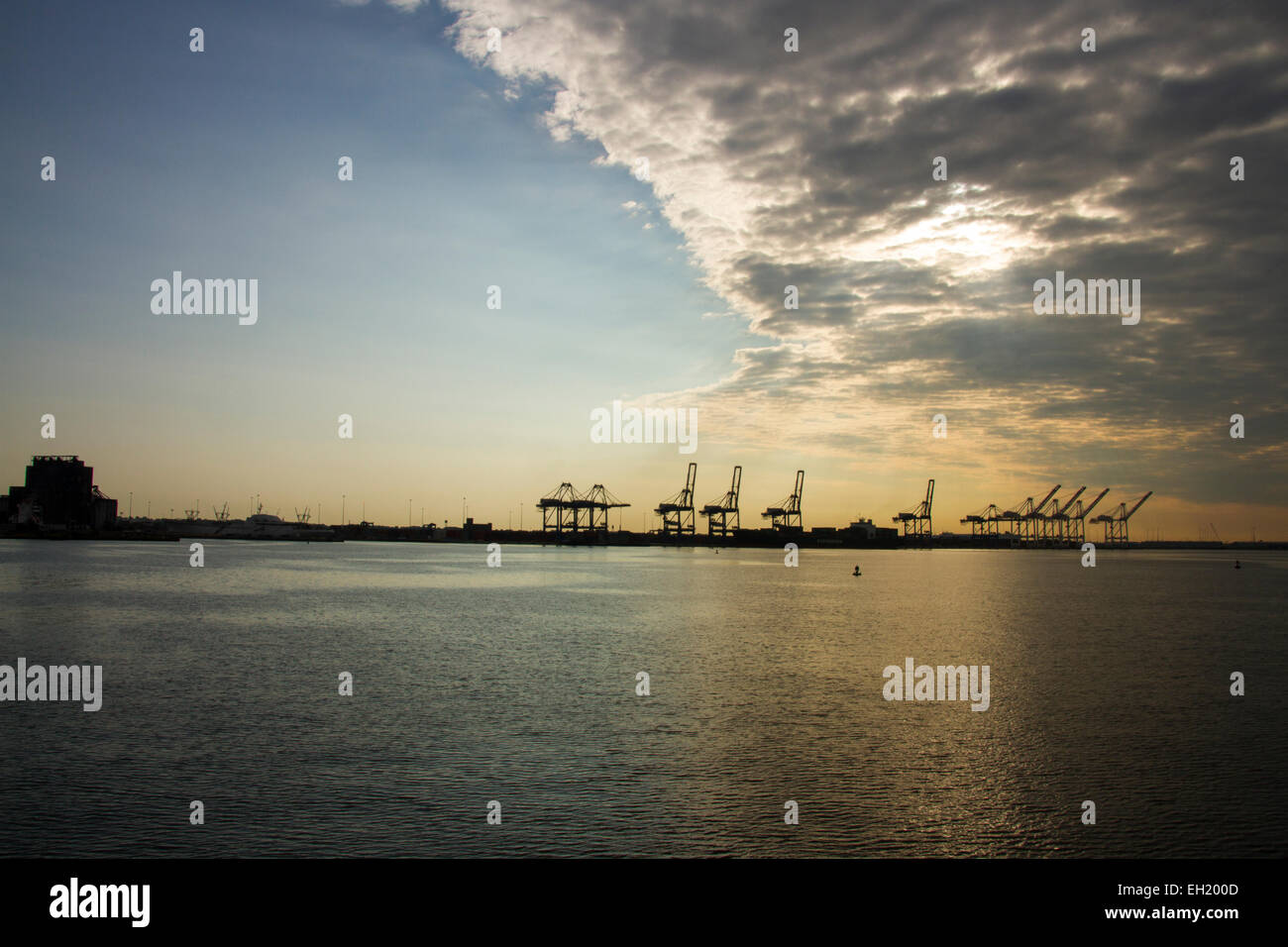 Tempesta davanti muoversi sopra il porto di Baltimora con contenitore silhouette di gru. Foto Stock