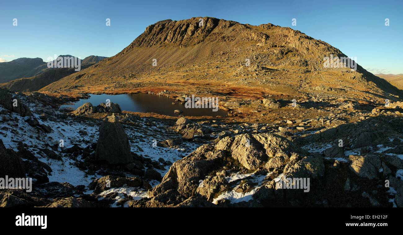 Bowfell e tre Tarns da Crinkle crags. Sera d'inverno luce su Bowfell e la gamma Scafell Foto Stock