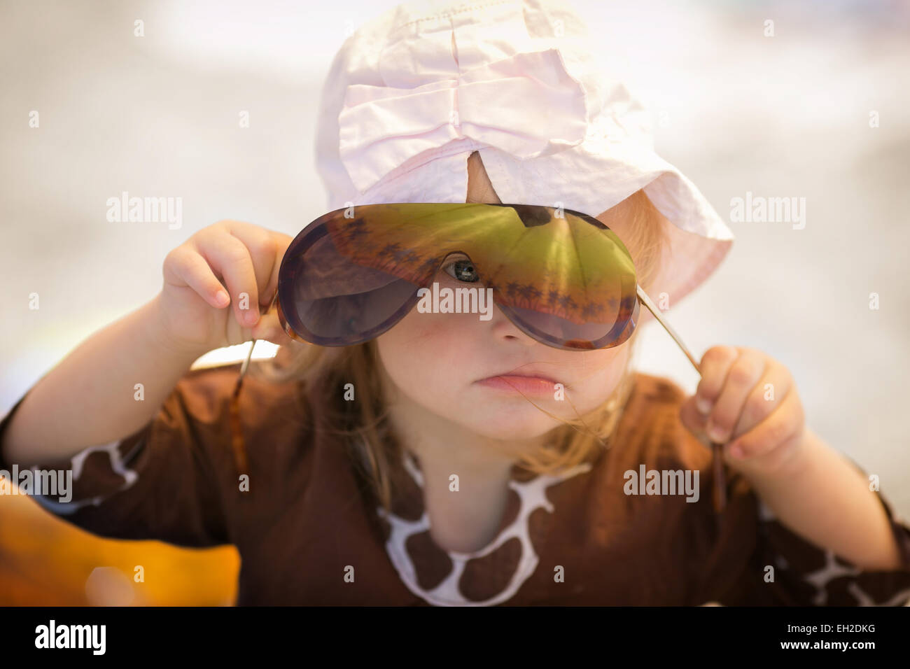 Allegro bambina con la sindrome di Down con gli occhiali in appoggio sulla costa del mare Foto Stock