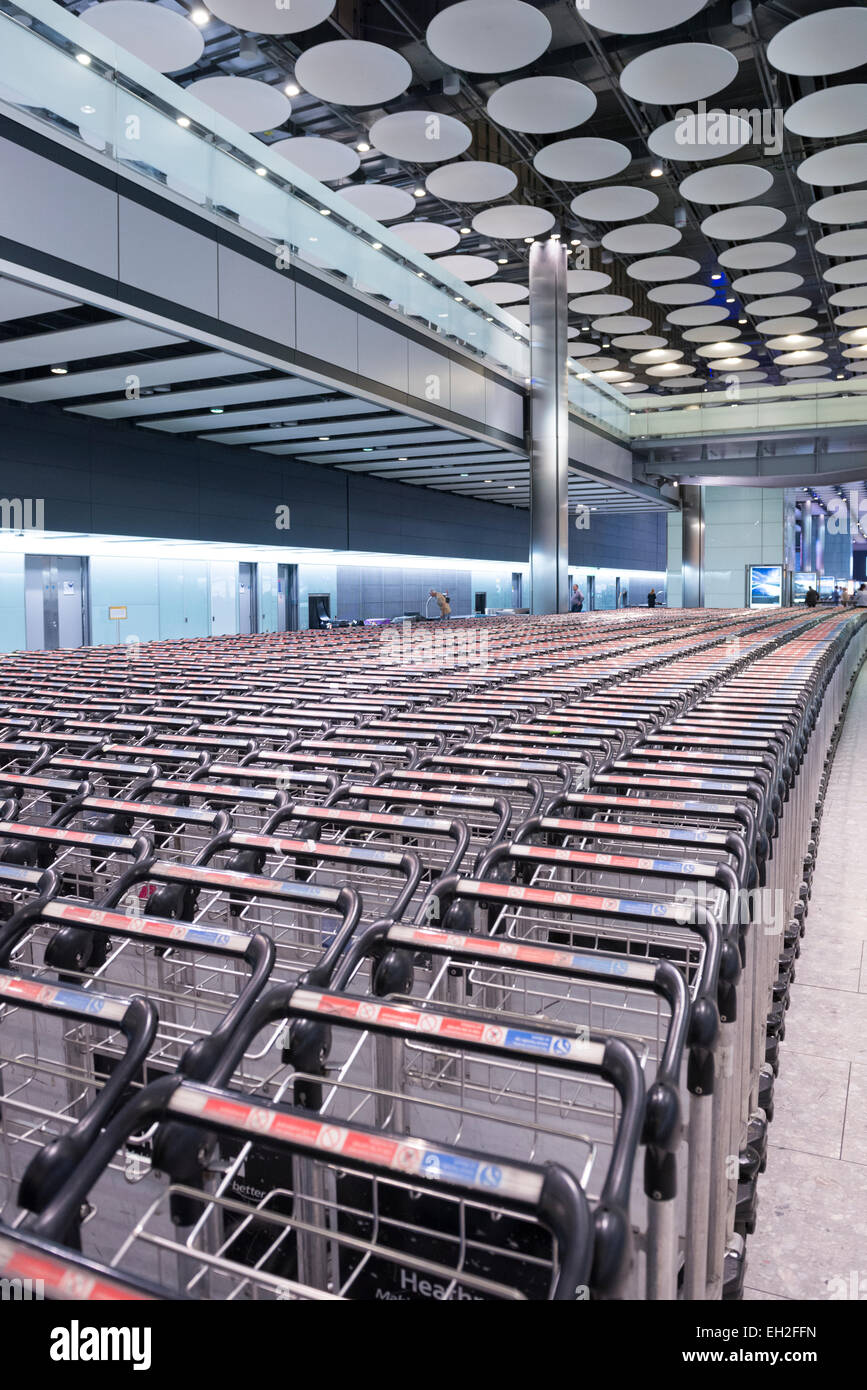 Linee di carrelli a Heathrow Airport Baggage collection Foto Stock