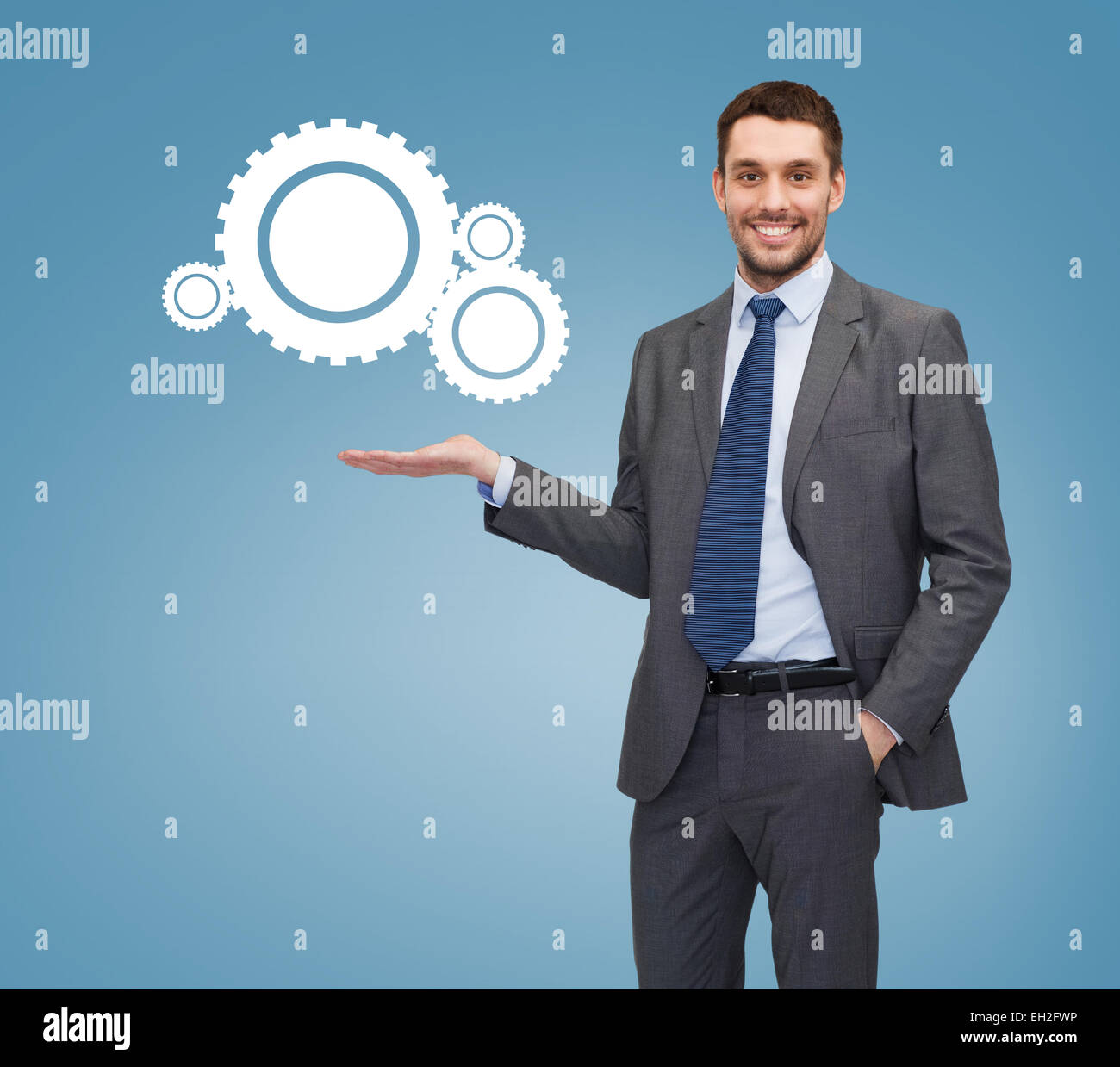 Imprenditore sorridente tenendo l'icona Impostazioni Foto Stock